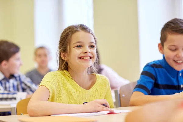 Grupp av skolbarnen skriva prov i klassrummet — Stockfoto