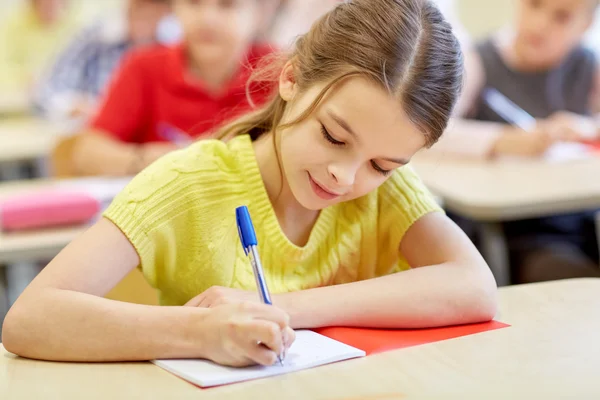 Group of school kids writing test in classroom Stock Picture