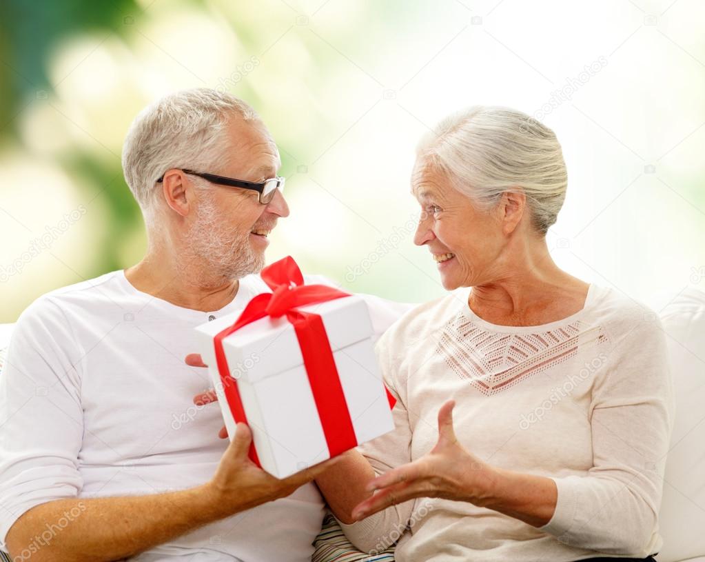 Heureux couple aîné avec boîte cadeau à la maison image libre de droit par  Syda_Productions © #63004041