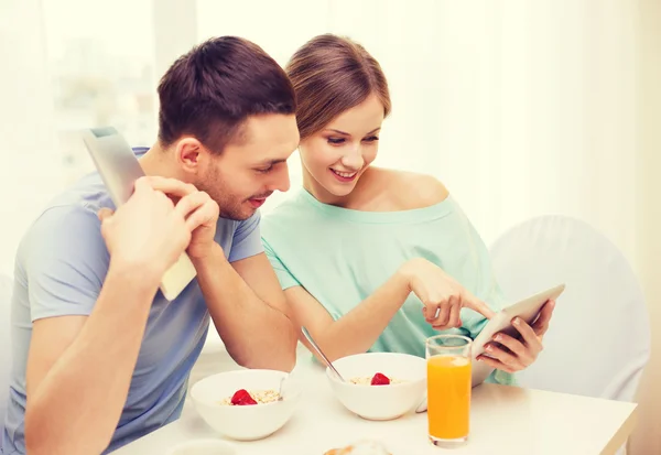 Pareja sonriente con tableta pc noticias de lectura —  Fotos de Stock