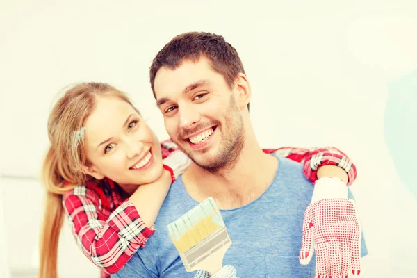 Casal sorridente coberto com tinta com pincel — Fotografia de Stock