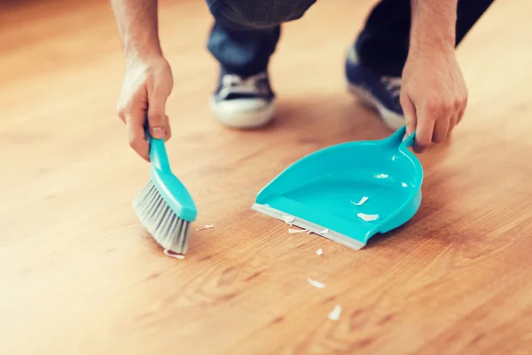 Close up of male brooming wooden floor — Stock Photo, Image