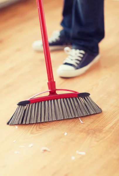 Close up of male brooming wooden floor — Stock Photo, Image