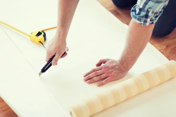 Close up of male hands cutting wallpaper — Stock Photo, Image