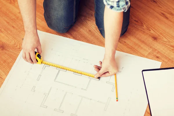 Close up of male hands measuring blueprint — Stock Photo, Image