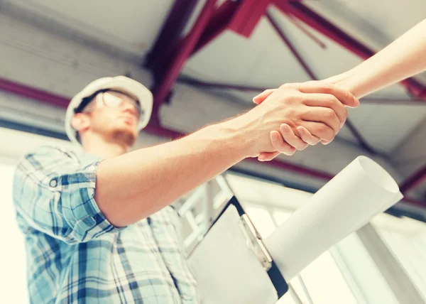 Builder with blueprint shaking partner hand — Stock Photo, Image