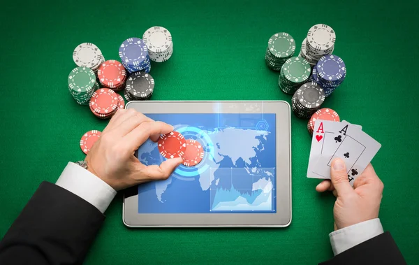 Joueur de poker casino avec cartes, tablette et jetons — Photo