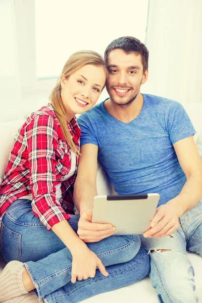Tablet pc を家庭で幸せなカップルの笑みを浮かべてください。 ロイヤリティフリーのストック写真