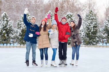 happy friends ice skating on rink outdoors clipart