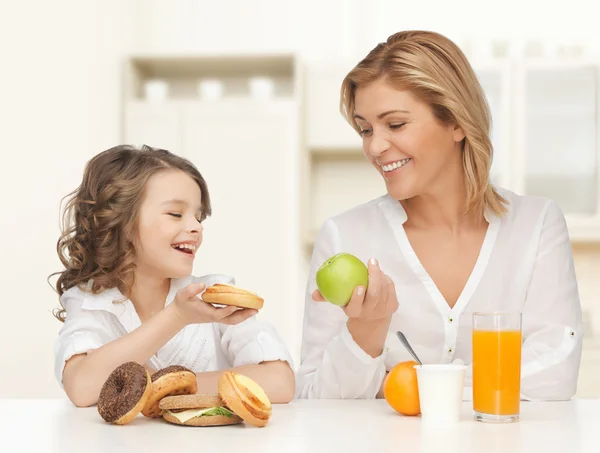 Mãe feliz e filha tomando café da manhã — Fotografia de Stock