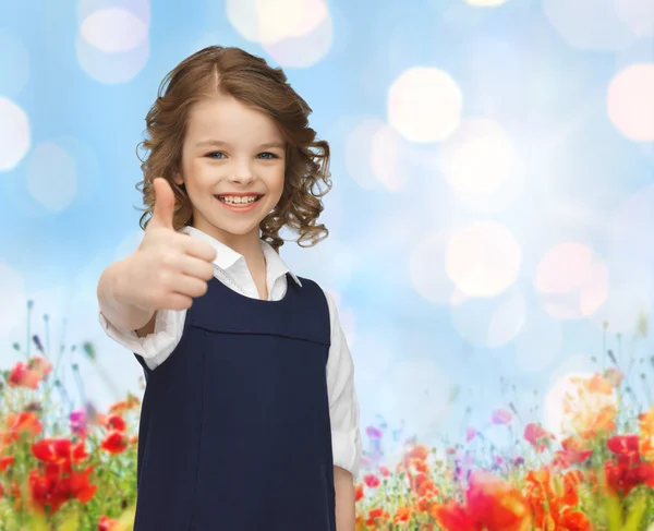 Щаслива маленька школярка показує великі пальці вгору — стокове фото