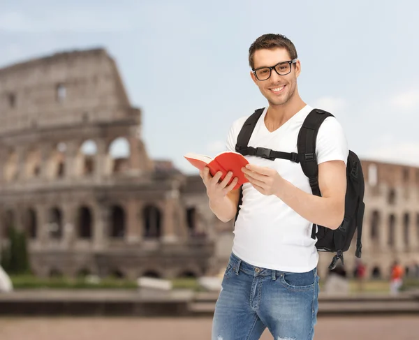 Glücklicher junger Mann mit Rucksack und Buch unterwegs — Stockfoto