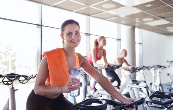 Grupp kvinnor ridning på motionscykel i gym — Stockfoto