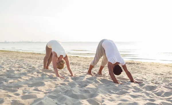 Pareja haciendo ejercicios de yoga al aire libre —  Fotos de Stock