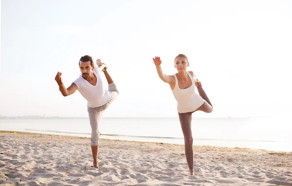 Пара делает упражнения йоги на открытом воздухе — стоковое фото