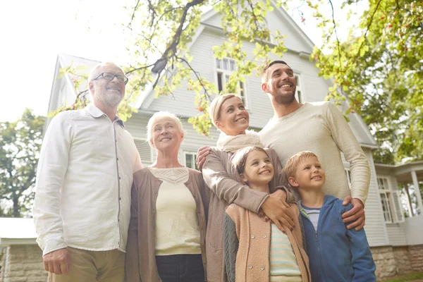 Familia feliz en frente de la casa al aire libre — Foto de Stock