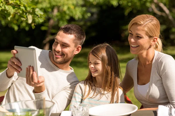 Счастливая семья с планшетным ПК на открытом воздухе — стоковое фото
