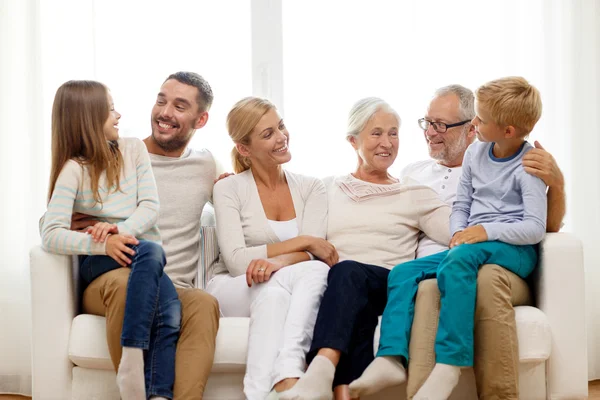 Happy family sitting on couch at home — Stock Photo, Image