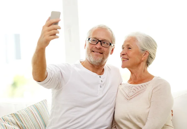 Felice coppia anziana con smartphone a casa — Foto Stock