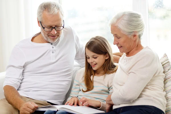 Smiling family with book at home — Stock Photo, Image
