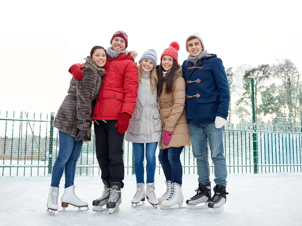 Amici felici pattinaggio sul ghiaccio sulla pista all'aperto — Foto Stock