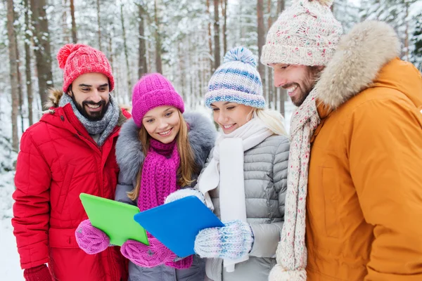 Amigos sorridentes com tablet pc na floresta de inverno — Fotografia de Stock