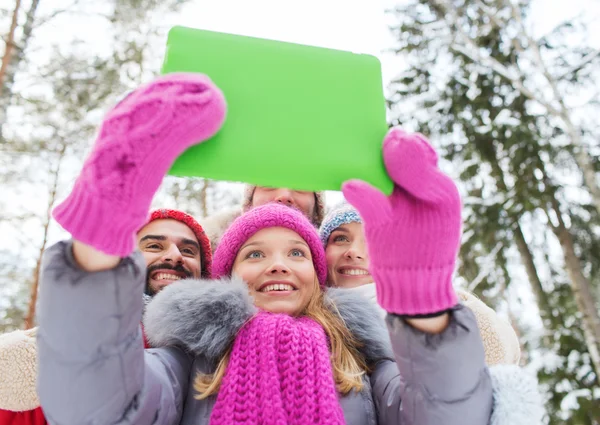 Amici sorridenti con tablet pc nella foresta invernale — Foto Stock