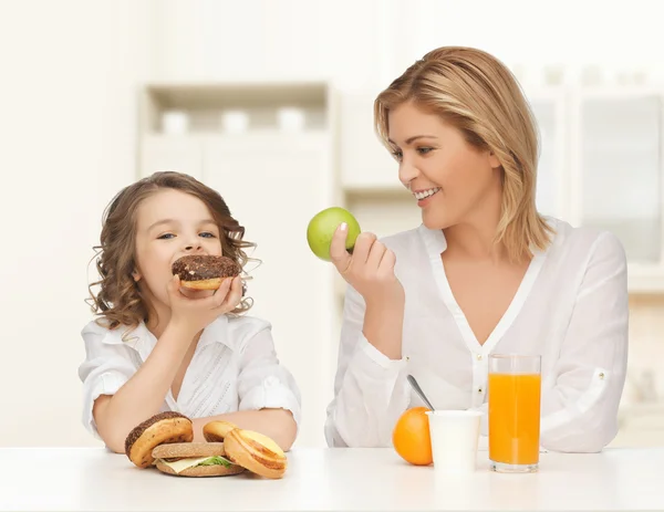 Gelukkig moeder en dochter eten ontbijt Stockfoto