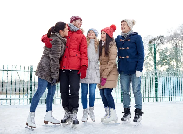 Happy friends ice skating on rink outdoors — Stock Photo, Image