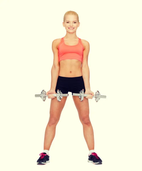 Smiling sporty woman with heavy steel dumbbells — Stock Photo, Image