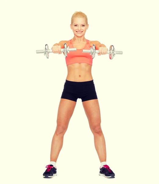 Lächelnde sportliche Frau mit schweren Stahlhanteln — Stockfoto