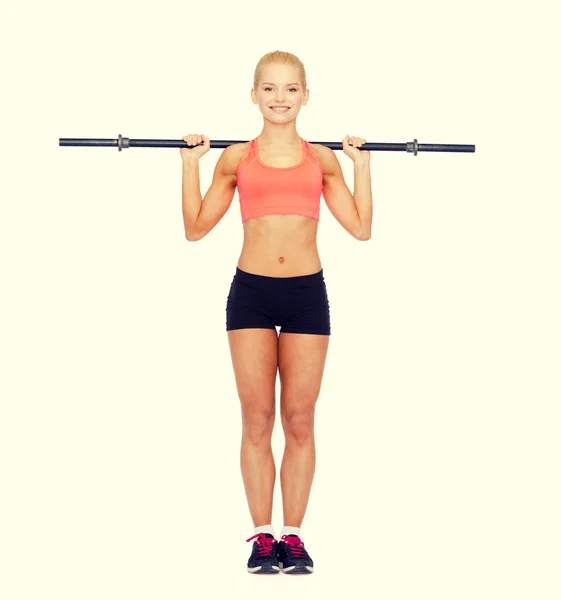 Glimlachende sportieve vrouw oefenen met lange halter — Stockfoto