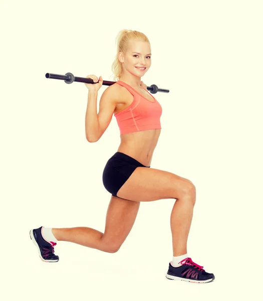 Sorrindo mulher desportiva exercitando com barbell — Fotografia de Stock