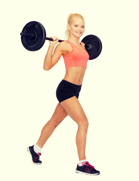 Sorrindo mulher desportiva exercitando com barbell — Fotografia de Stock