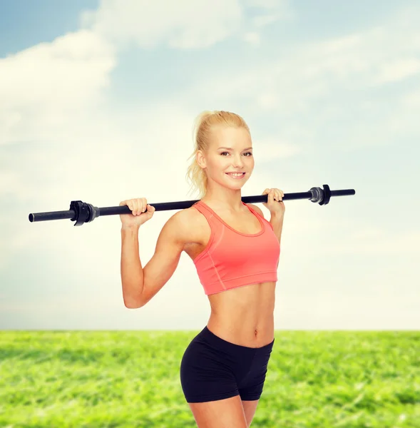 Lächelnde sportliche Frau beim Training mit der Langhantel — Stockfoto