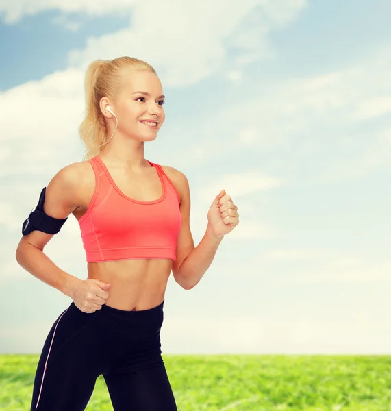 Mujer deportiva corriendo con smartphone y auriculares — Foto de Stock