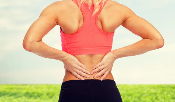 Close up of sporty woman touching her back — Stock Photo, Image