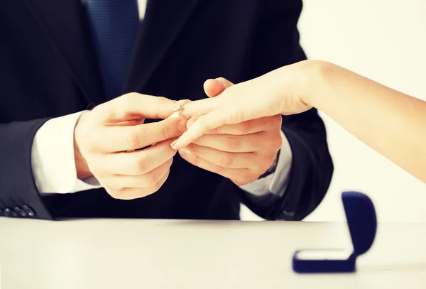 Hombre poniendo anillo de boda en la mano de la mujer — Foto de Stock