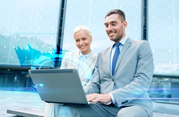 Smiling businesspeople with laptop outdoors — Stock Photo, Image