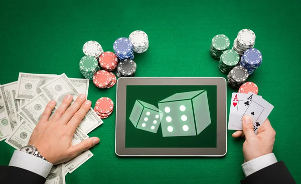 Joueur de poker casino avec cartes, tablette et jetons — Photo