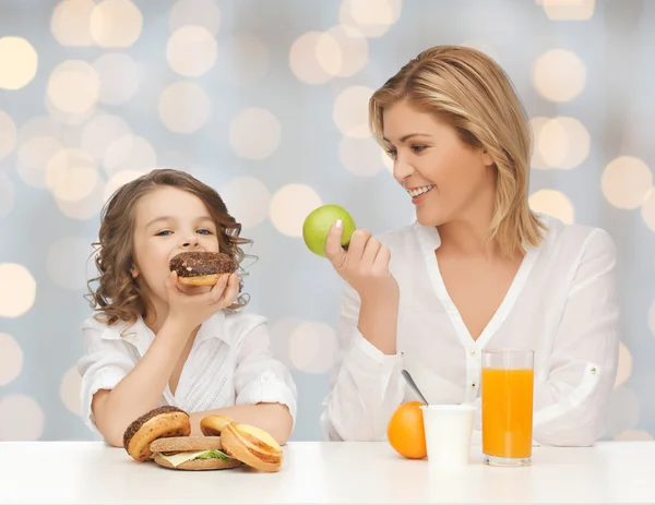 Mãe feliz e filha tomando café da manhã — Fotografia de Stock