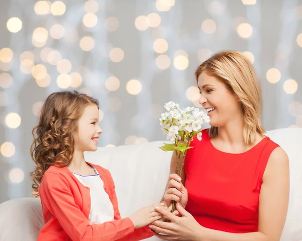 Gelukkig dochtertje bloemen geven haar moeder — Stockfoto