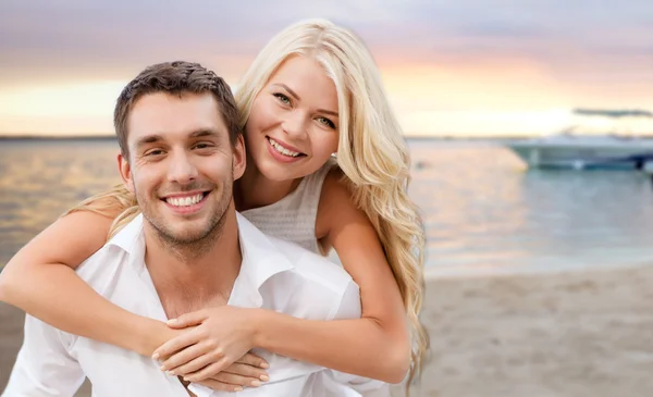 Felice coppia avendo divertimento su spiaggia sfondo — Foto Stock