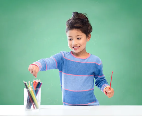 Happy school girl drawing with coloring pencils — Stock Photo, Image