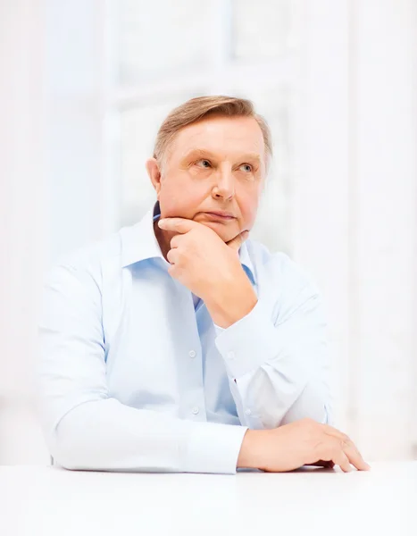 Stressed old man holding head at home — Stock Photo, Image