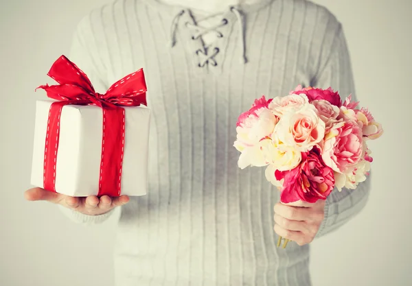 Hombre sosteniendo ramo de flores y caja de regalo —  Fotos de Stock