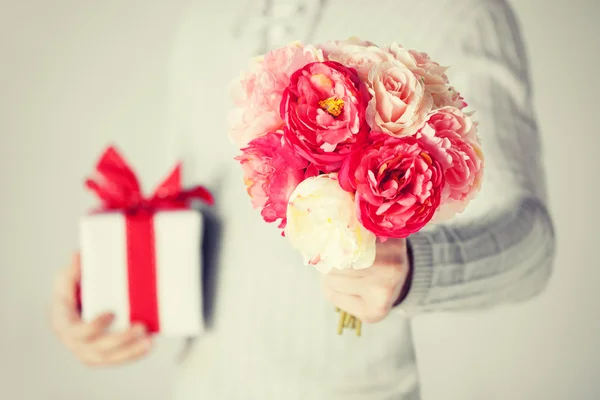 Man med bukett av blommor och presentförpackning — Stockfoto