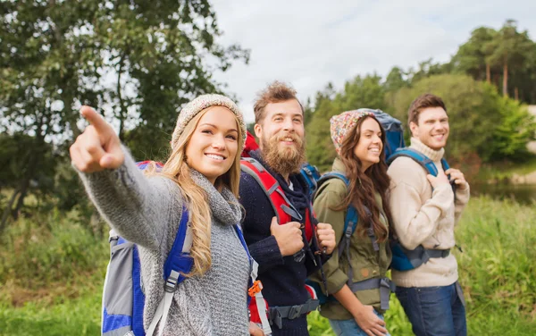 Group of smiling friends with backpacks hiking — Stock Photo, Image