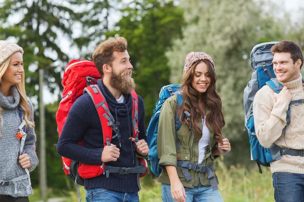 Grupo de amigos sonrientes con mochilas senderismo — Foto de Stock
