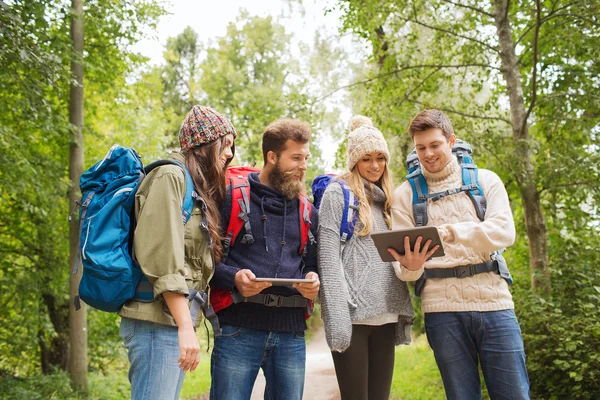 Groep vrienden met rugzakken en tablet pc — Stockfoto